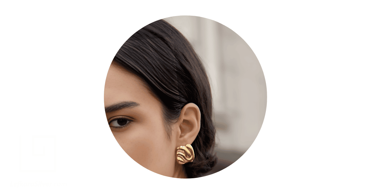 a woman wearing a bold gold earring.