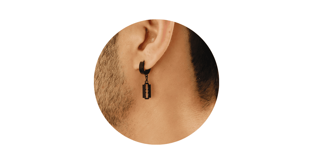 a man's ear adorned with a black hoop/razor drop earring.