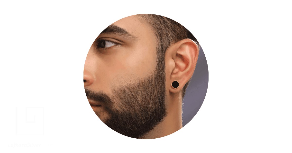 a man wearing a black stud earring.
