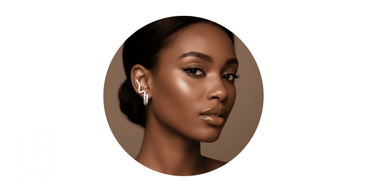 A woman with a square-shaped face, wearing ear climbers.