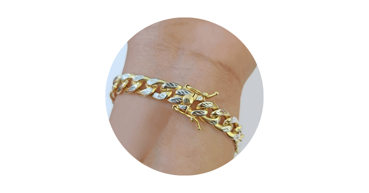 A person's wrist adorned with a gold bracelet.
