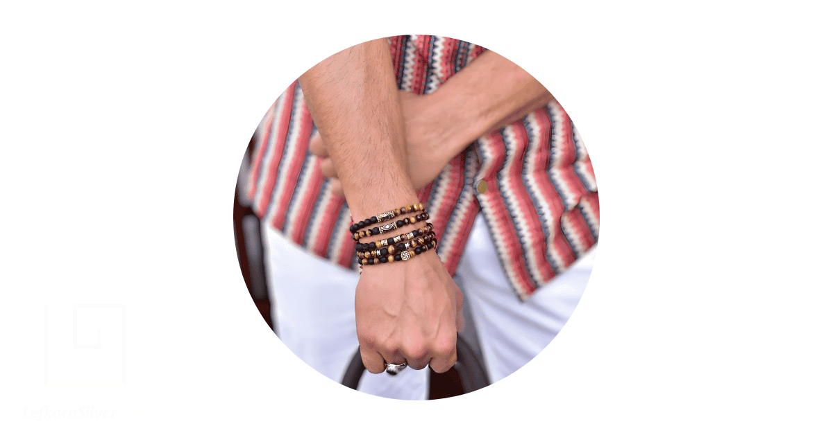 A man's wrist adorned with bead bracelets.