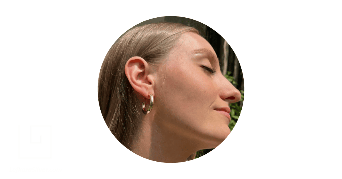 a woman wearing gold hoop earrings.