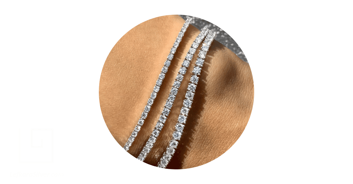 a person's wrist adorned with tennis bracelets. 