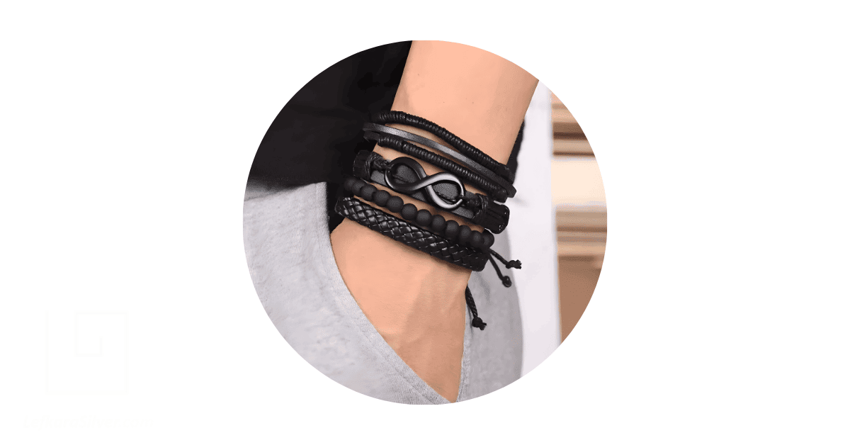 A man's wrist adorned with black bracelets.