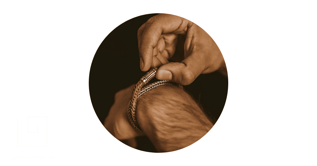A man's wrist adorned with leather bracelets.