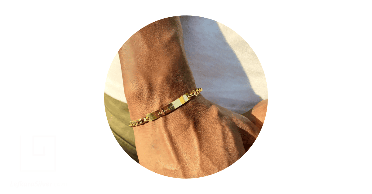 A man's wrist adorned with a gold bracelet for men.