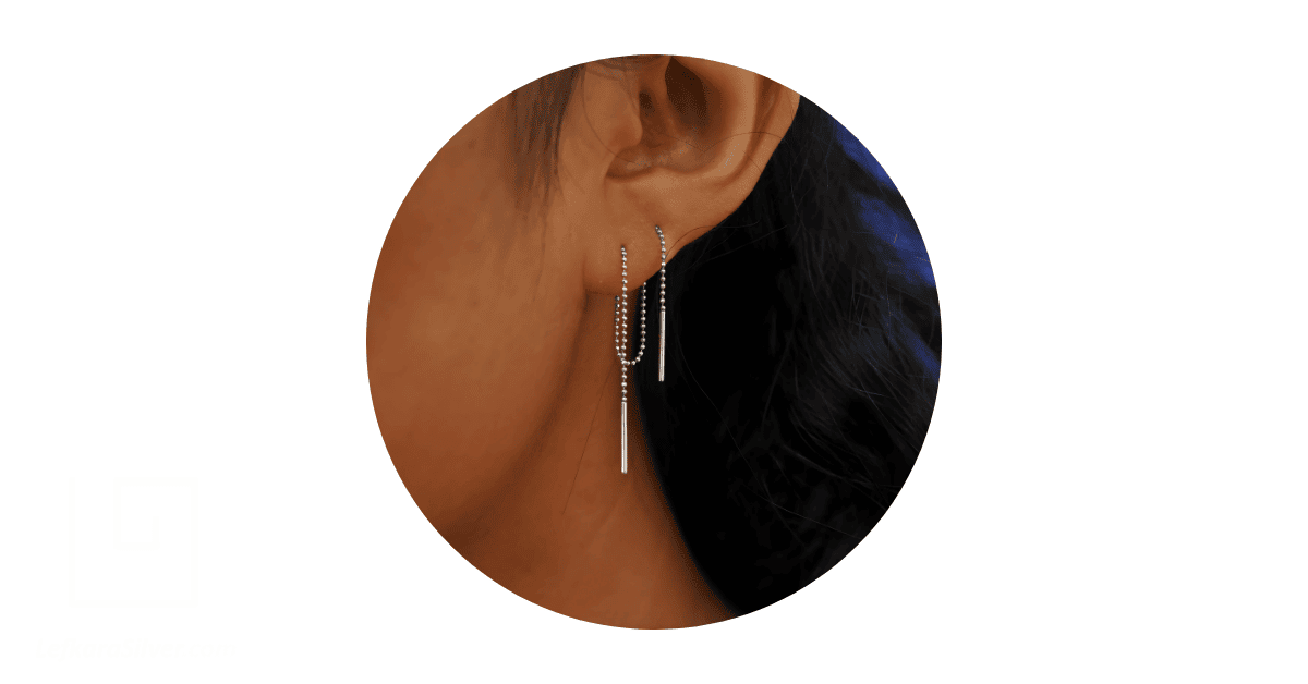 a person's ear adorned with threader earrings.