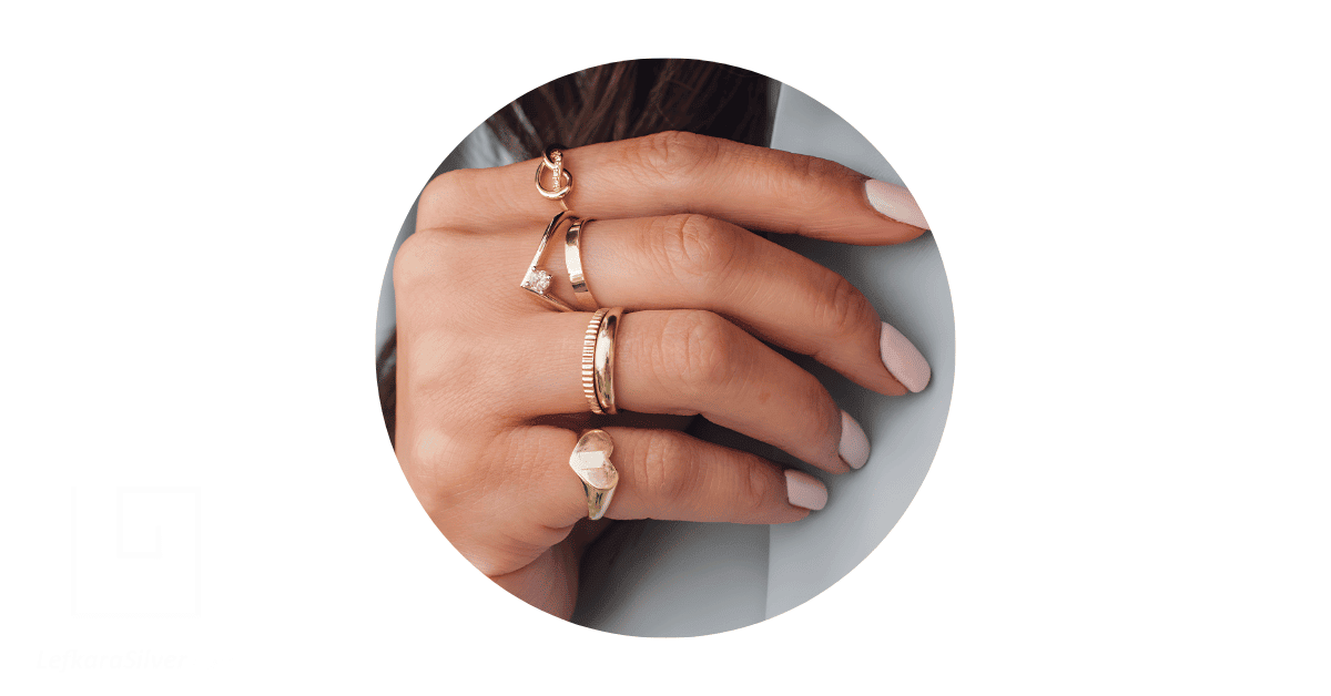 a person's fingers stacked with rings.