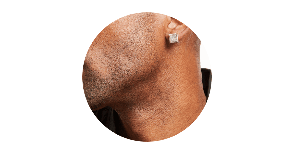 a man's ear adorned with a diamond stud earring.