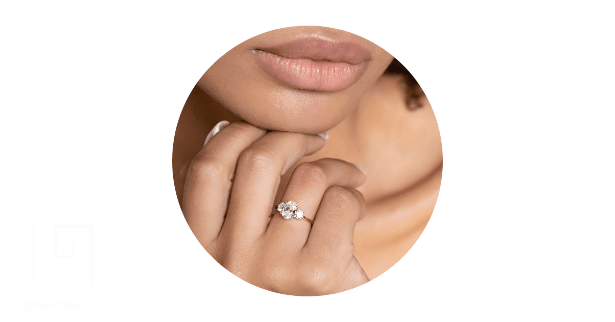 a woman's finger adorned with a simple engagement ring.