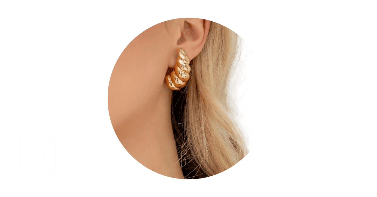 a woman wearing gold hoop earrings.