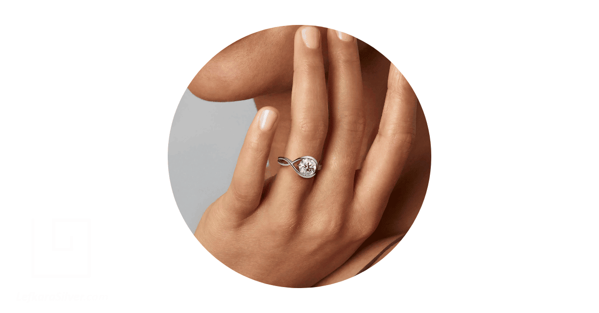 a woman's finger adorned with a white gold ring.