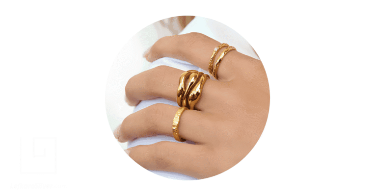 A person's fingers adorned with gold rings.