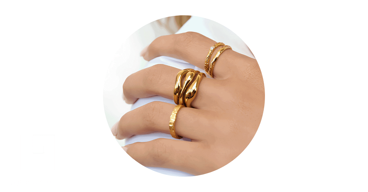 A person's fingers adorned with gold rings.