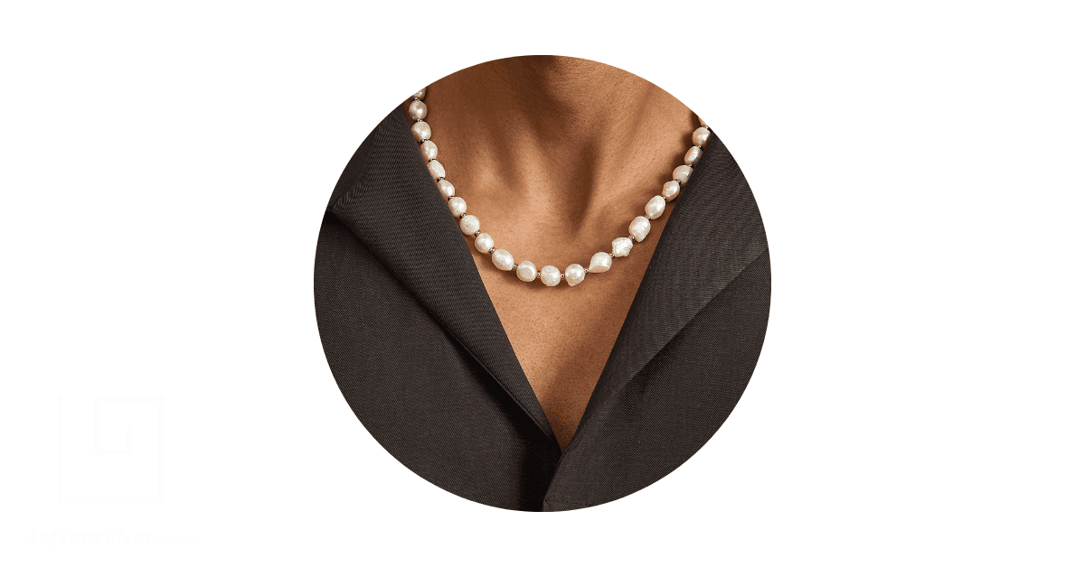 a man's neck adorned with a pearl necklace.