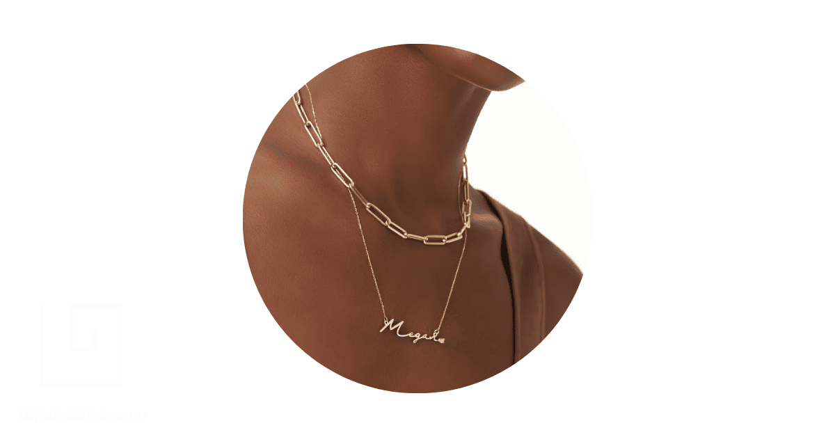 a person's neck adorned with a layered necklace. 