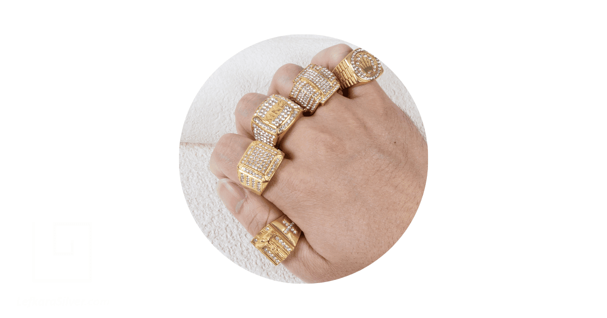 a man's fingers adorned with different men's gold rings with diamonds.