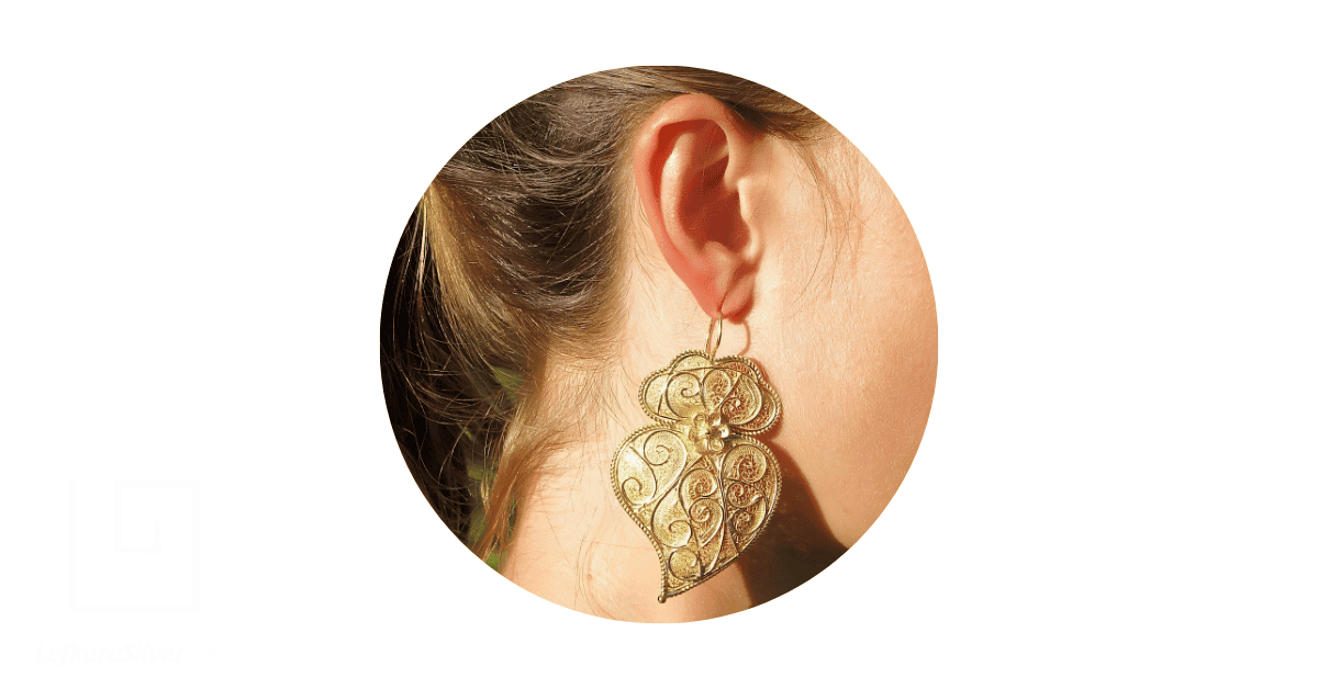 a woman's ear adorned with a gold drop earring.
