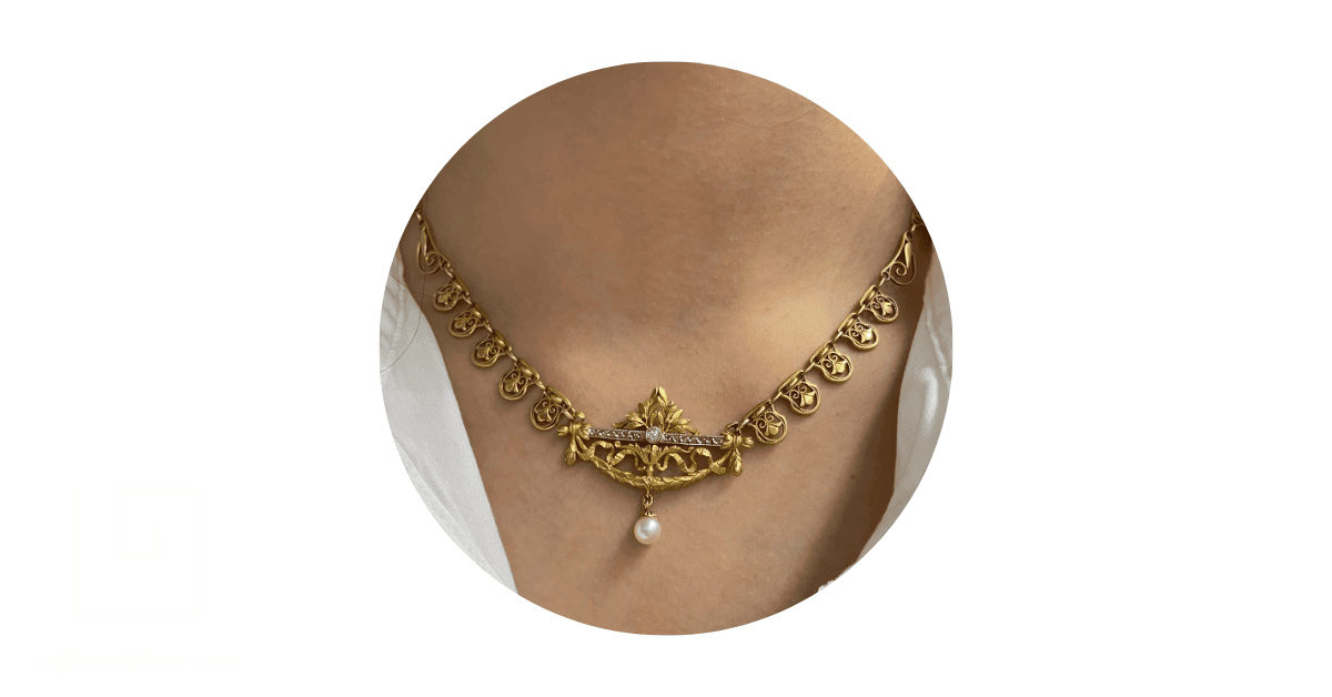 A person's neck adorned with a French filigree necklace.