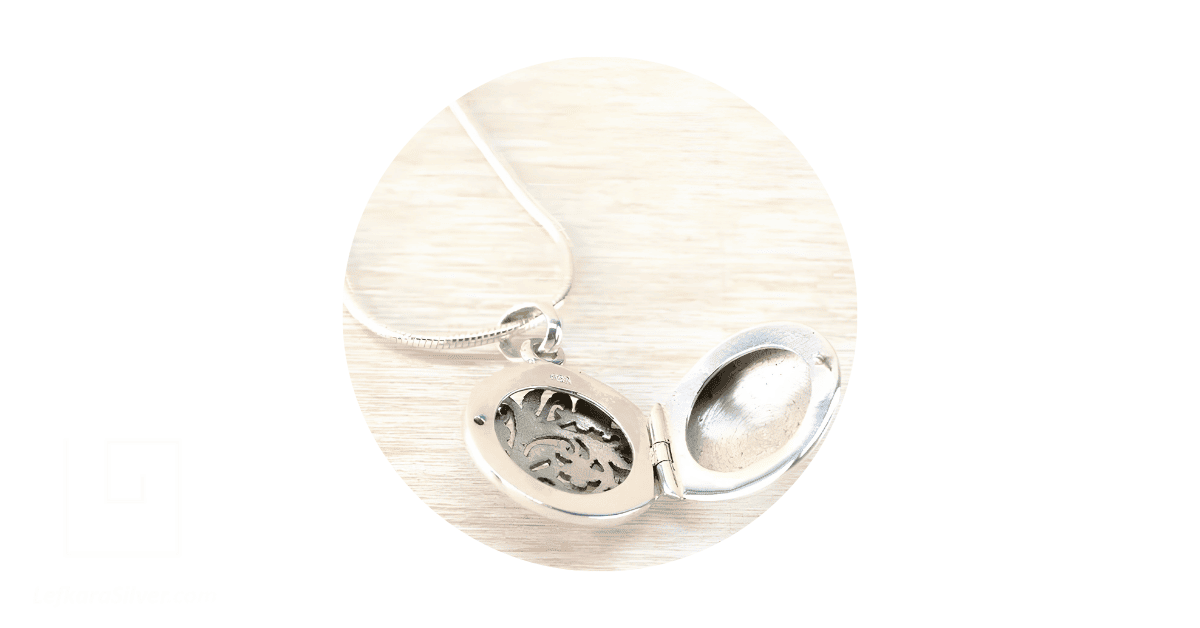 An open silver filigree locket.