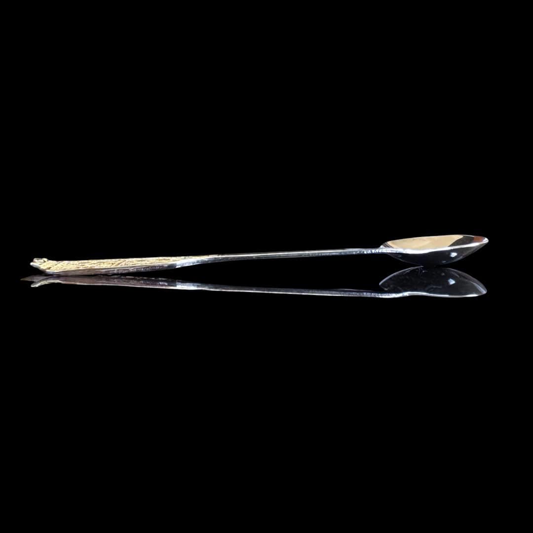 Handmade silver baby feeding spoon with an elongated bowl and lacelike filigree handle, by Lefkara Silver Cyprus.