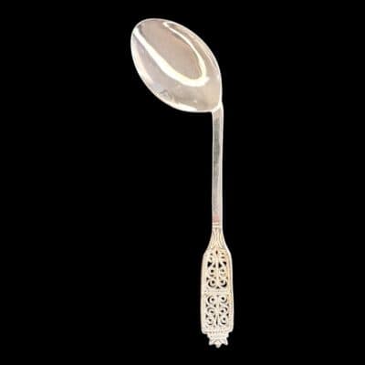 Handmade silver baby feeding spoon with an elongated bowl and lacelike filigree handle, by Lefkara Silver Cyprus.