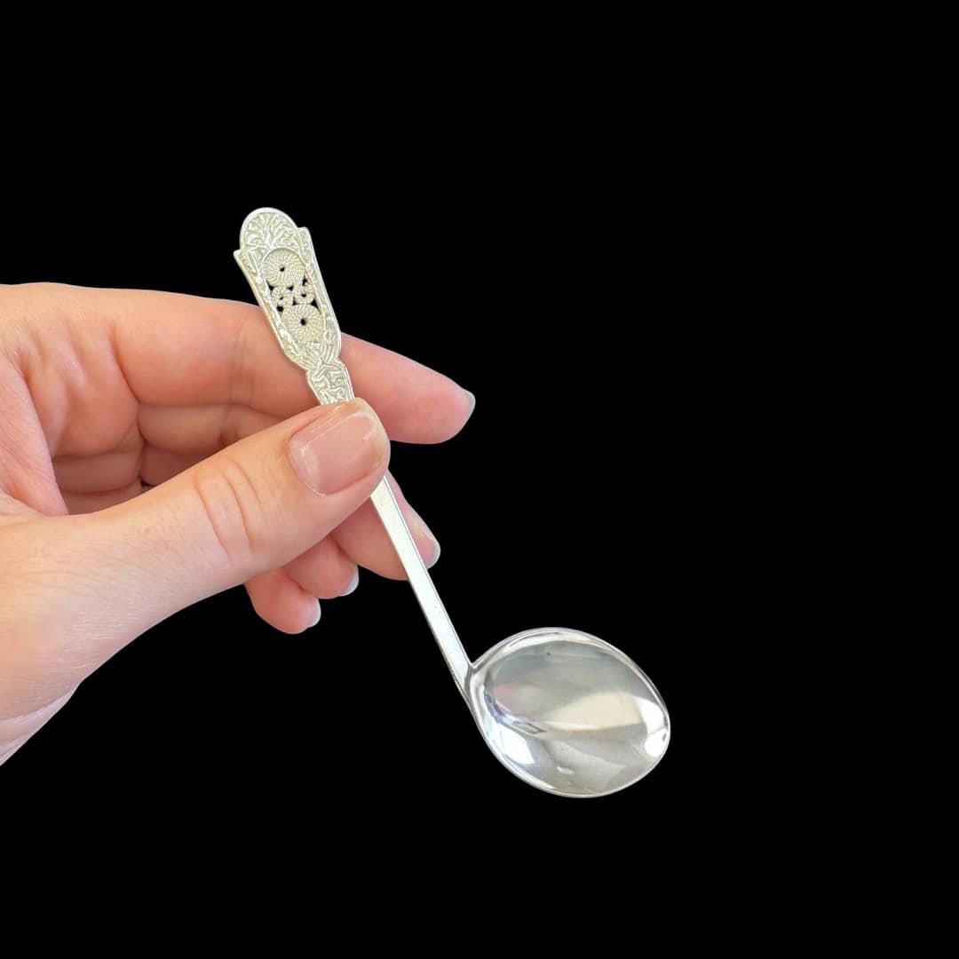 Handmade silver baby feeding spoon with an engraved pierced medallion handle, by Lefkara Silver Cyprus.